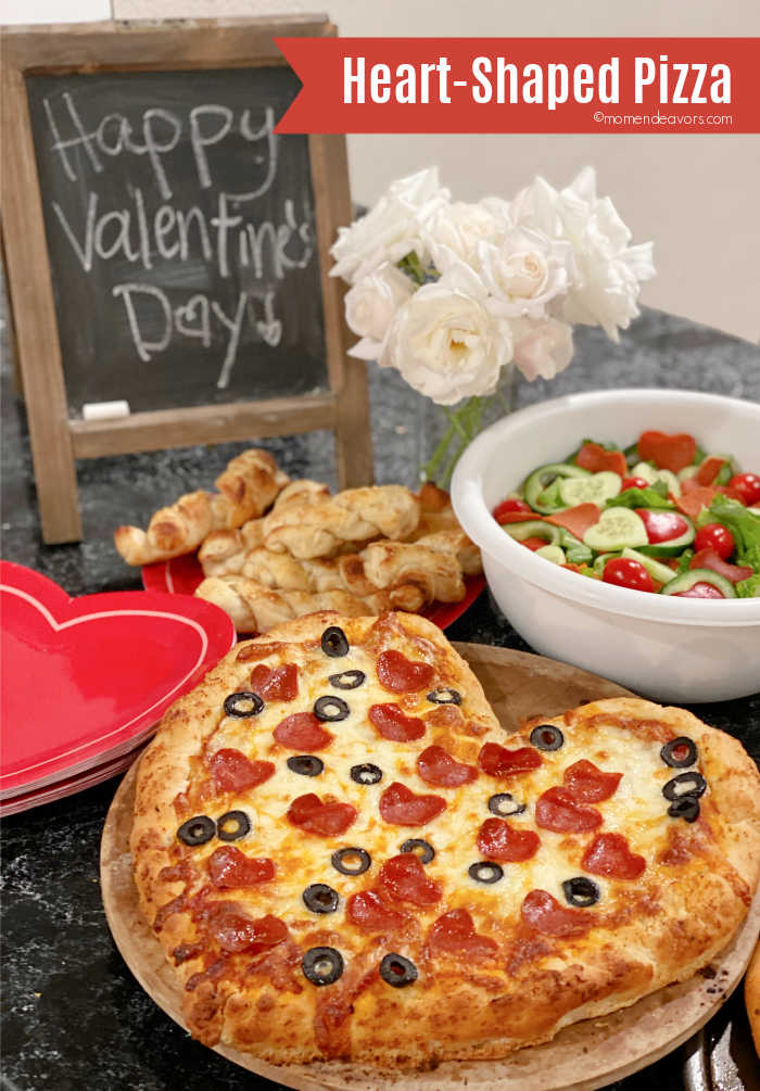 Valentine's Day dinner spread with a heart-shaped pizza