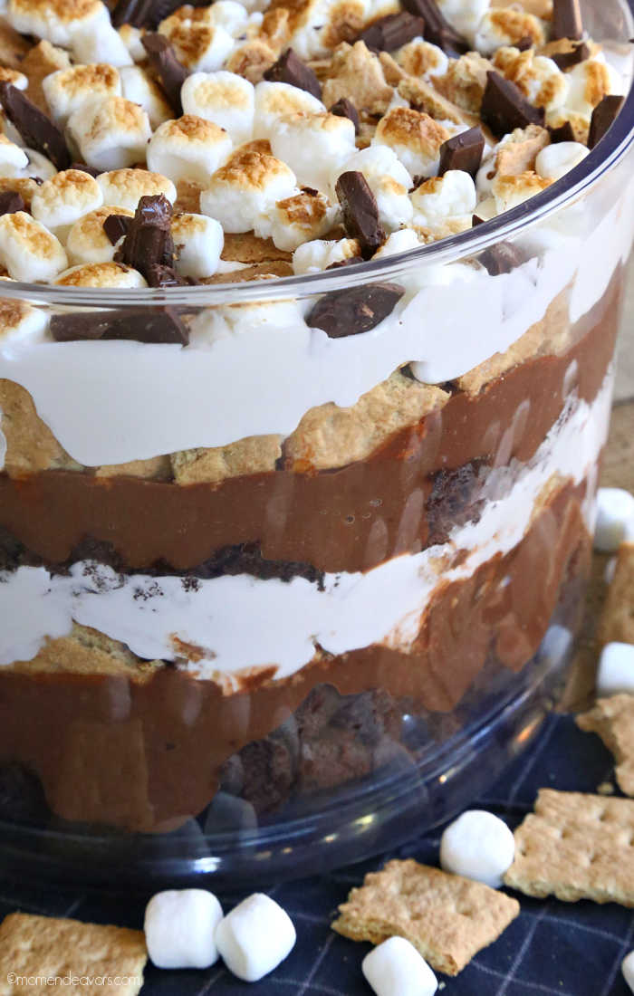 Layers of brownie s'mores dessert in a glass trifle dish