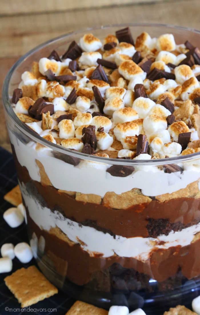 S'mores Trifle Dessert in a glass trifle dish with marshmallows and graham cracker pieces scattered.