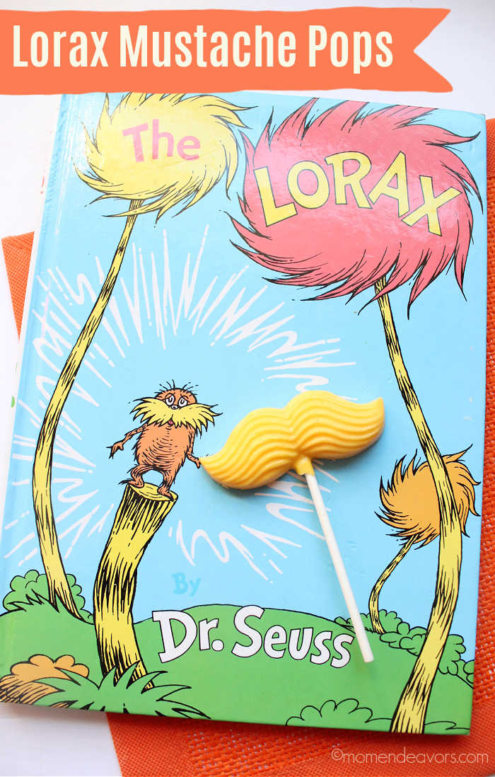 A yellow candy mustache pop sits on top of The Lorax book by Dr. Seuss