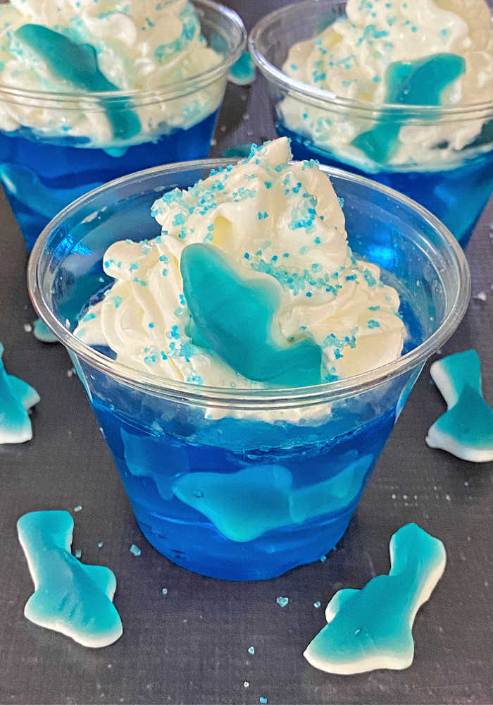 Blue Jello with gummy sharks and whipped cream