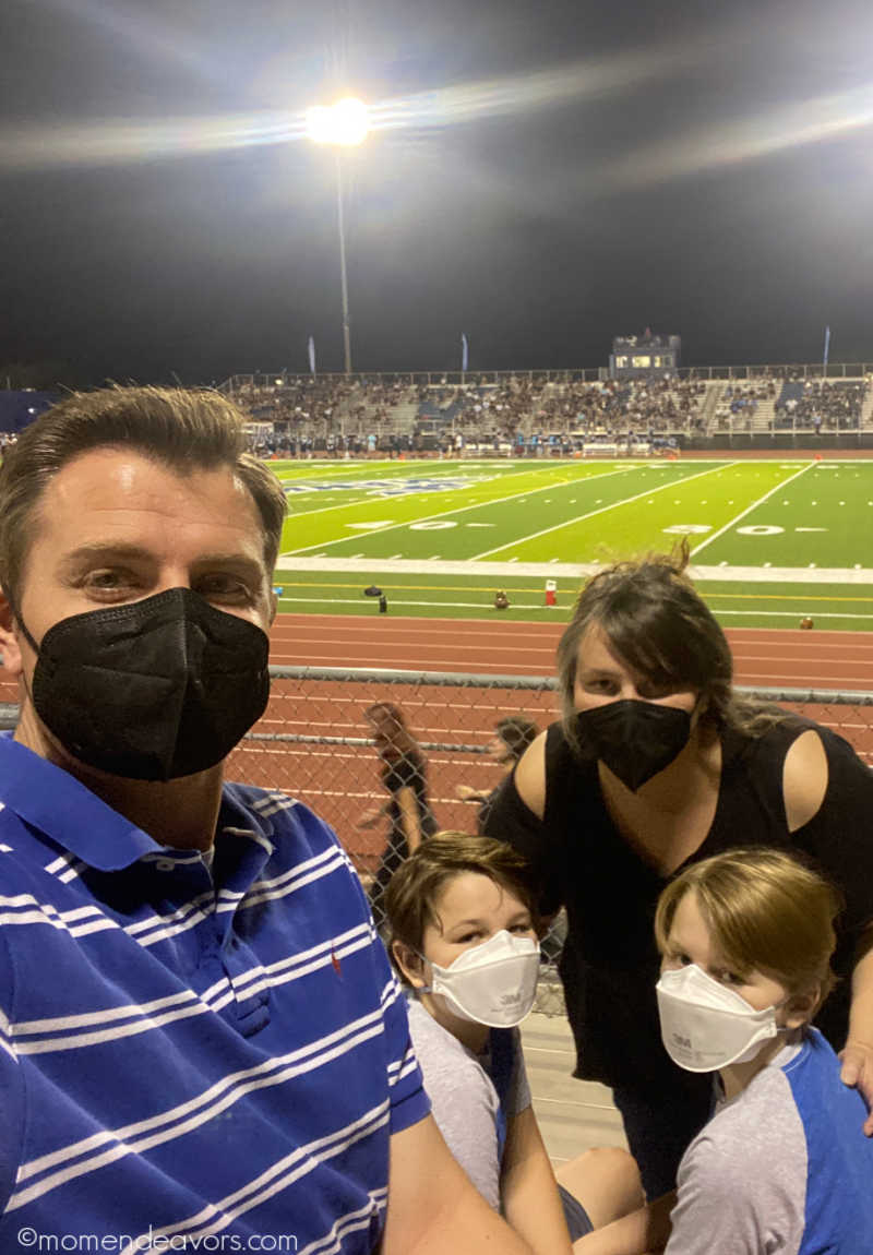 A family wearing high filtration masks at a football game